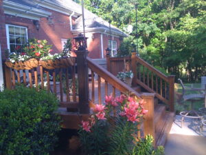 A wooden deck with flowers growing on it.