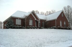 A brick house with snow on the roof.