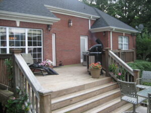 A large deck with stairs leading to the back patio.