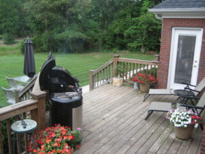 A bbq on top of a wooden deck.