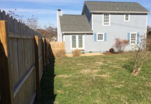 A backyard with a fence and grass