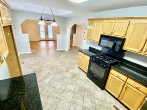 A kitchen with black appliances and wooden cabinets.