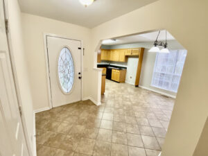 A kitchen with tile floors and white walls.