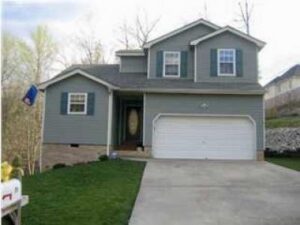 A house with a garage and driveway in front of it.