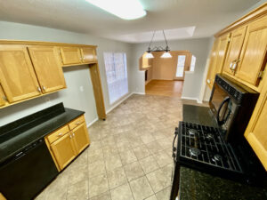 A kitchen with wooden cabinets and black appliances.