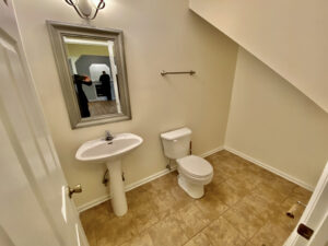 A bathroom with a sink, toilet and mirror.