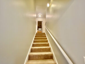 A long hallway with stairs leading to the top floor.