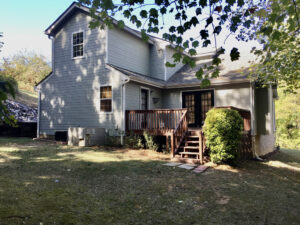 A house with a deck and steps in the yard.