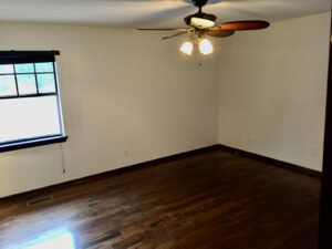 A room with wood floors and ceiling fan.