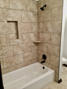 A bathroom with tile walls and a bathtub.