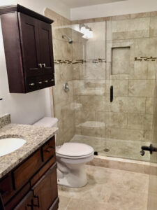 A bathroom with marble tile and granite counter tops.