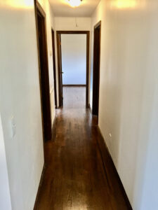 A hallway with two doors and wooden floors.