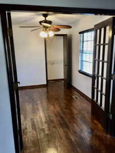 A room with wood floors and a ceiling fan.