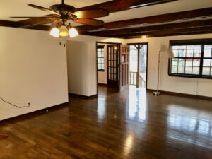 A room with wooden floors and ceiling fans.