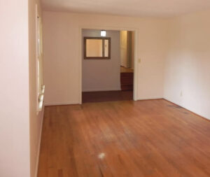 A room with wood floors and white walls.