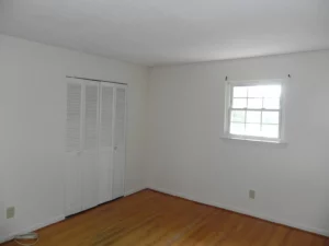 A room with white walls and wooden floors.