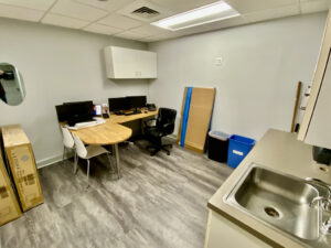 A room with a sink, table and chairs.