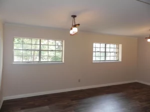 A room with two windows and a ceiling fan.