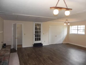 A room with hard wood floors and white walls.