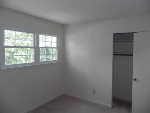 A room with white walls and a refrigerator.