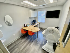 A room with a table, chair and television.