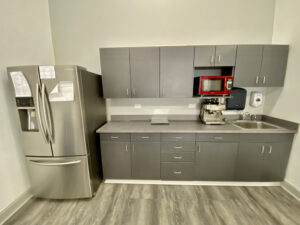 A kitchen with gray cabinets and stainless steel appliances.