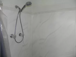 A shower head and hand held shower heads in a bathroom.