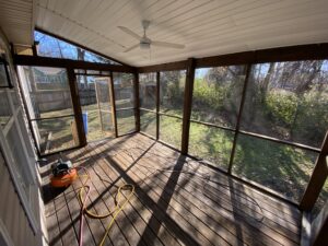 A room with a lot of windows and a ceiling fan