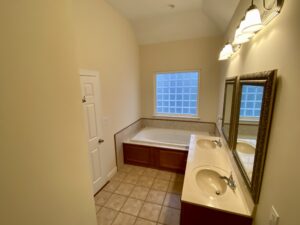 A bathroom with two sinks and a large tub.