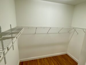 A white room with a wooden floor and shelves.