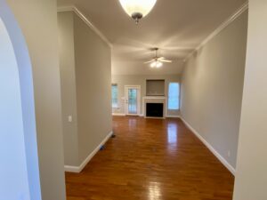 A living room with hard wood floors and white walls.