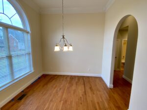 A room with hard wood floors and a large window.