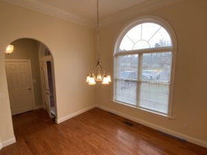 A room with hard wood floors and a large window.