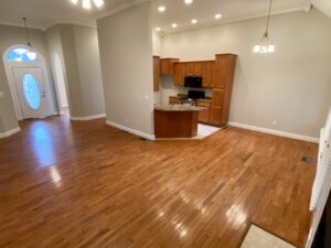 A room with hard wood floors and a kitchen.