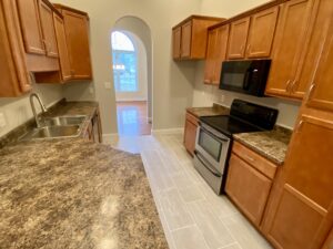 A kitchen with wooden cabinets and granite counter tops.