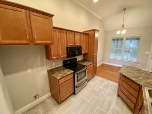 A kitchen with wooden cabinets and granite counter tops.