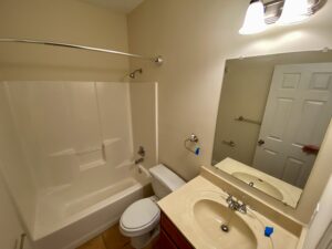 A bathroom with a toilet, sink and tub.