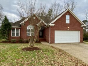 A brick house with a tree in front of it.