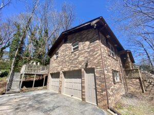 A garage with two doors and a wooden deck.