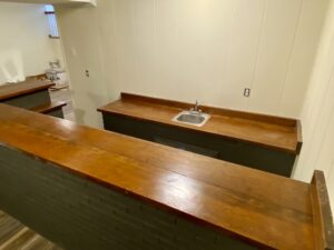 A kitchen with wooden counters and black cabinets.