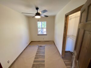 A room with a ceiling fan and a window.