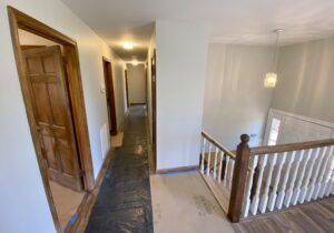 A hallway with wooden doors and white walls.