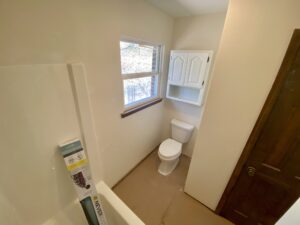 A bathroom with a toilet and window in it