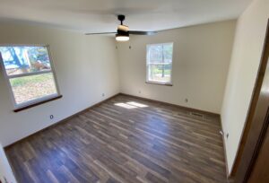 A room with wood floors and a ceiling fan.