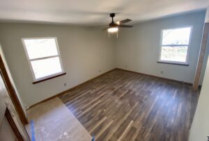 A room with hard wood floors and ceiling fan.