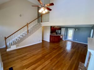 A living room with hard wood floors and a ceiling fan.