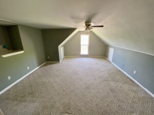 A room with an open ceiling and a window.