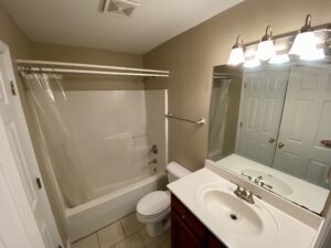 A bathroom with a toilet, sink and bathtub.