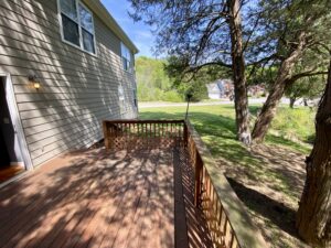 A wooden deck with a tree in the background.