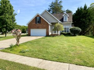 A house with a driveway and lawn in front of it